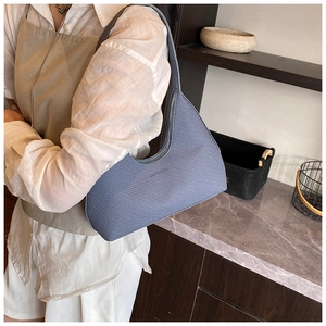 Detailed view of light blue embossed leather hobo bag with zip and subtle logo