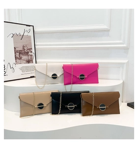 Détail de sacs enveloppes avec bandoulières en chaîne dorée et boucles en métal