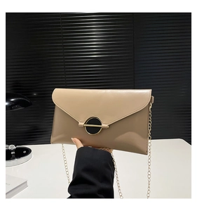 Détail du sac bandoulière beige avec boucle dorée et chaîne élégante en métal