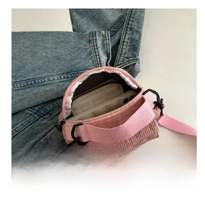 Detail showing inner capacity of pink corduroy crossbody bag with smartphone and pouch