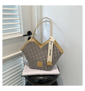 Close-up of houndstooth tote bag with V-cut edge and golden fashion brand logo