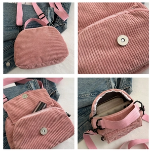 Detail view of pink corduroy messenger bag featuring magnetic flap and textile strap