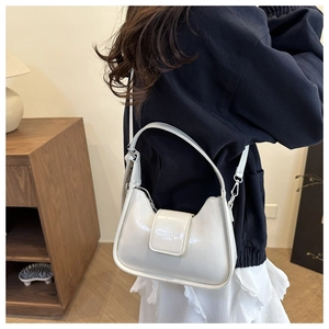 Detail of white glossy crescent moon bag featuring embossed FASHION & BAGS logo and handle