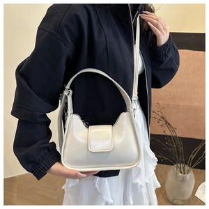 Detailed close-up of cream white glossy leather shoulder bag with buckle and logo