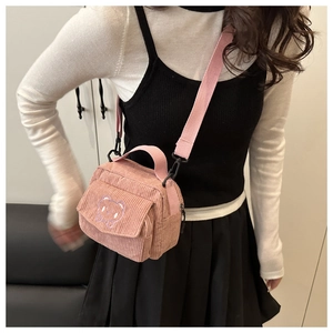 Detailed view of pink corduroy crossbody bag with cute bear embroidery and wide strap