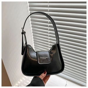 Close-up of black crescent shoulder bag featuring adjustable buckle and silver hardware