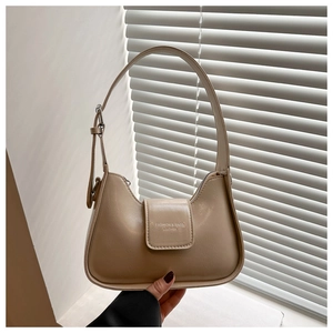 Detail of hobo bag with magnetic flap closure and adjustable strap in beige finish