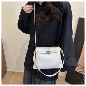 Detail of white leather Kelly bag showing silver turn-lock and adjustable shoulder strap