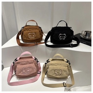 Row of corduroy shoulder bags in four colors with cute bear embroidery on white display