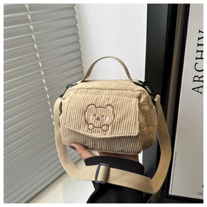 Detail of corduroy crossbody bag with cute bear embroidery and adjustable strap