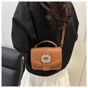 Brown lychee leather handbag featuring a square rhinestone buckle and elegant top handle