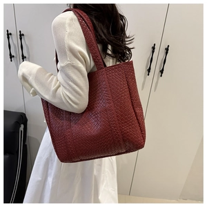 Close-up of burgundy woven tote bag with a checkered texture and long shoulder straps