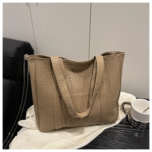 Close-up of beige woven leather texture and shoulder straps on a large tote bag