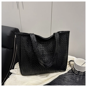 Detail of black woven texture on high-capacity minimalist tote bag in a lifestyle setting