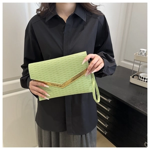 Detail of mint green envelope clutch with water ripple texture and golden V-shaped trim
