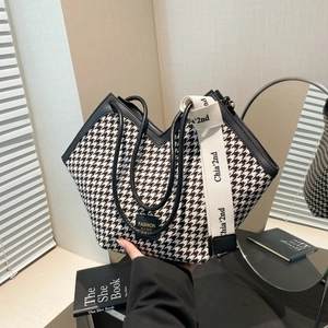 Houndstooth tote bag with V-shaped opening, wide woven strap, and black PU trim