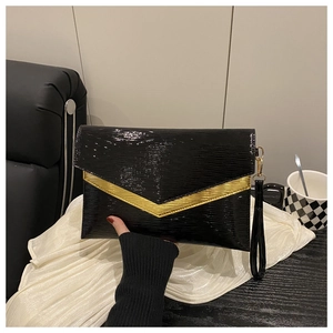 Detail of black envelope clutch featuring elegant wave-textured patent leather and gold V-accent