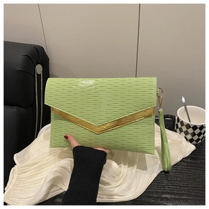 Detail of light green envelope clutch with wavy texture and golden V-shaped metal trim