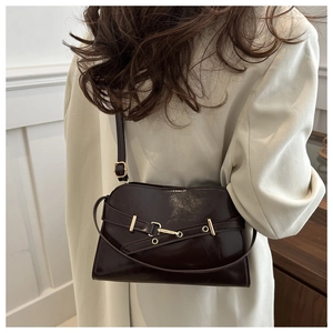 Detailansicht der braunen Vintage-Tasche aus glänzendem Leder mit modischer Schnalle