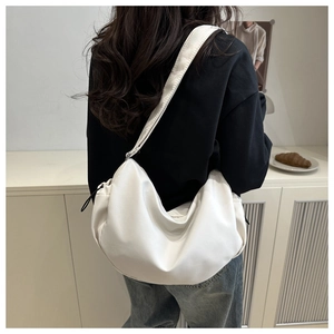 Detailed view of a white nylon crescent crossbody bag with drawstrings and wide strap