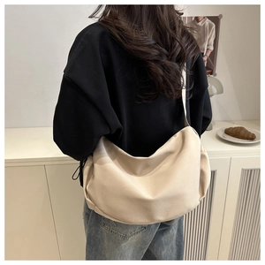 Detailed back view of a large beige crescent tote bag styled in a modern home setting