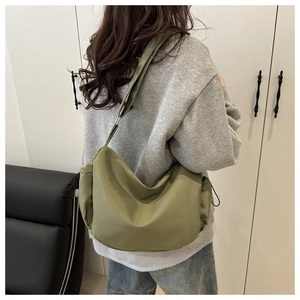 Detail of an olive green nylon hobo bag showing the soft water-resistant fabric and drawstring