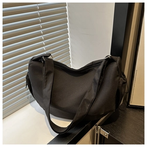 Detail of a large black hobo bag with side drawstrings and comfortable wide shoulder strap