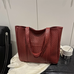 Minimalist burgundy woven leather tote bag with large capacity in a lifestyle setting