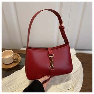 Détail d'un sac à main vintage rouge vin avec boucle de verrouillage dorée en métal
