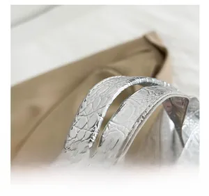 Detail showing comfortable double straps and shiny crocodile embossed silver texture