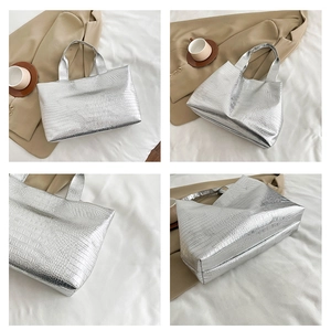 Detail of silver crocodile pattern tote bag with large capacity and glossy finish