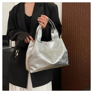 Close-up of silver croc-effect tote bag with metallic sheen and wide handles