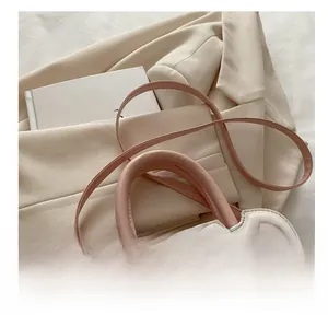 Close-up of white and pink leather handbag with wavy edges and studio logo detail