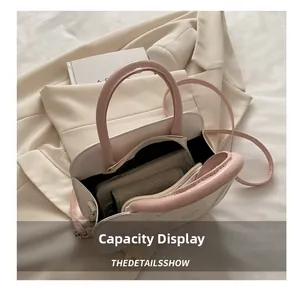 Interior capacity display of a white crossbody bag showing daily items with zipper closure