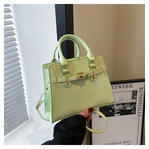 Detail showing mint green vegan leather texture and golden twist-lock on handbag