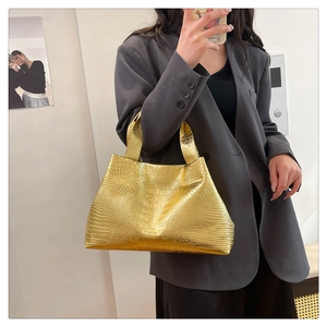 Chic gold tote bag with embossed crocodile texture shown in a mirror selfie style
