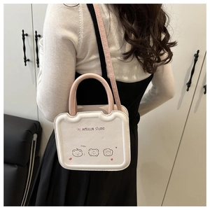 Detail of white mini lunch box bag with cartoon bear prints and pink shoulder strap