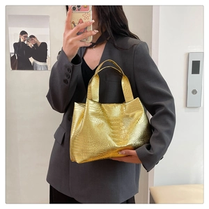 Detailed view of the gold crocodile embossed texture on a large capacity tote bag for women
