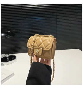 Close-up of beige quilted mini bag featuring a gold rose-shaped metal twist lock and chain