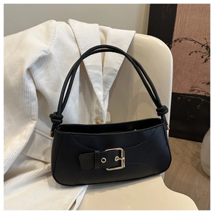 Detailed macro view of the black leather bag with a vintage gold buckle and knot detail