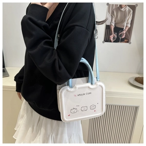 Close-up of white and blue crossbody bag with cute cartoon bears and handle detail