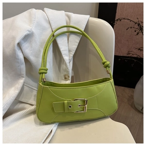 Detail of bright green shoulder bag featuring golden buckle and stylish knotted strap