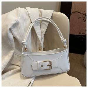 Close-up of white leather baguette bag with a gold buckle and knotted shoulder strap