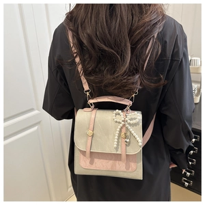 Détails du sac à dos bicolore gris et rose avec pendentif nœud en perles sur le dos