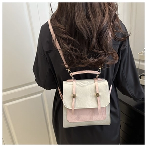 Close-up of pink and silver matte leather backpack featuring gold circular metal hardware