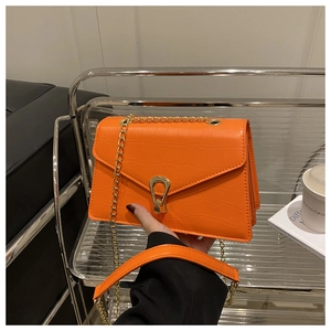 Detail of bright orange crocodile pattern PU leather crossbody bag with golden U-shaped lock