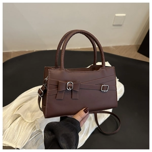 Close-up of coffee brown crossbody bag with matte finish and decorative metal buckle