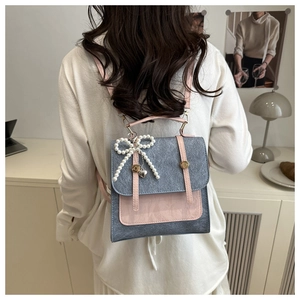 Détail du mini sac à dos en tweed bleu et cuir rose avec nœud perlé et cœur pendentif