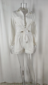 Detail of white two-piece set featuring a tie-waist button-up shirt and elastic high-waisted shorts