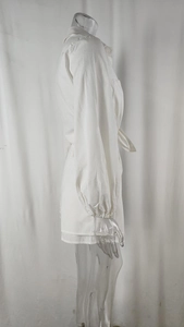 Detail of white cotton linen shirt set with long cuffed sleeves and waist bow tie